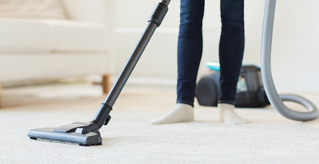 woman maintaining soft carpet with a vacuum